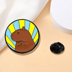 Broche émaillée ronde motif capybara avec rayons bleus et jaunes et fermoir noir