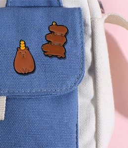 Détail de pins Capybara en émail sur un sac en toile, motifs mignons d'orange et empilables