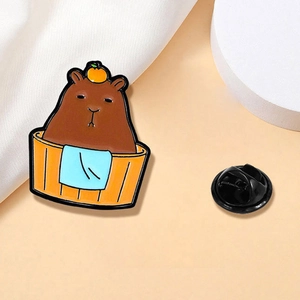 Détail du pin's émaillé capybara dans un bain avec orange et fermoir en caoutchouc noir