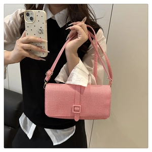 Detail of pink and white striped woven crossbody bag with decorative square buckle