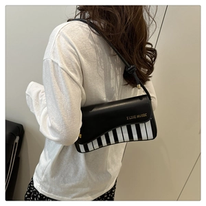 Detail showing musical piano key pattern and I LIKE MUSIC print on stylish black PU bag