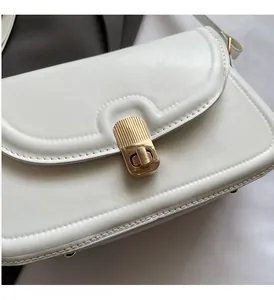 Vue rapprochée du sac en cuir blanc avec grain lychee et fermoir métallique doré chic