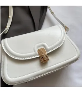 Détail du sac à bandoulière blanc avec fermoir doré rotatif et coutures fines