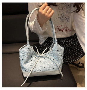 Dettaglio della borsa tote trapuntata azzurra con grande fiocco decorativo e nastri