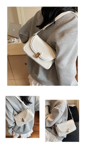Détail du sac bandoulière en cuir blanc avec fermoir doré et bandoulière réglable