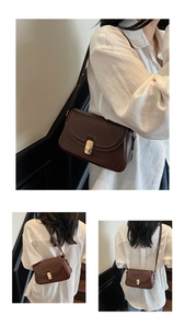 Détail du sac bandoulière marron foncé avec boucle métallique dorée à texture verticale