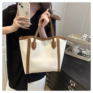 Detail of vintage contrast tote bag with off-white body and dark brown handles