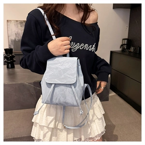 Close-up of light blue mini backpack with unique crinkled texture and drawstring closure
