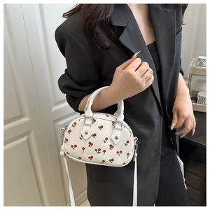 Close-up of sweet cherry print handbag with silver hardware and detachable strap
