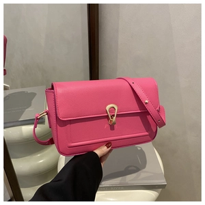 Detailed close-up of pink pebbled leather handbag with an elegant gold metallic clasp