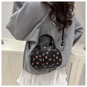 Detail of cute cherry print mini bag showing crossbody style and adjustable strap