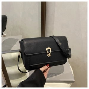 Detail of lychee pattern leather handbag with gold U-shaped hardware buckle closure