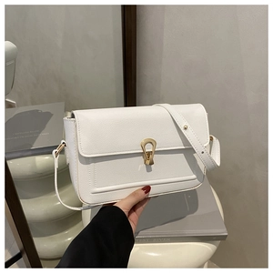 Close-up of white lychee grain leather crossbody bag with golden teardrop metal clasp