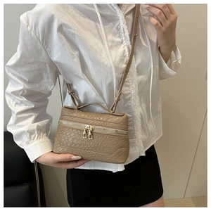 Detail of khaki crocodile pattern square bag featuring golden zippers and a top handle