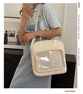 Close-up of beige nylon crossbody bag with large clear window and adjustable strap