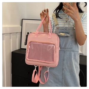 Close-up of pink convertible backpack featuring a transparent window and nylon mesh detail