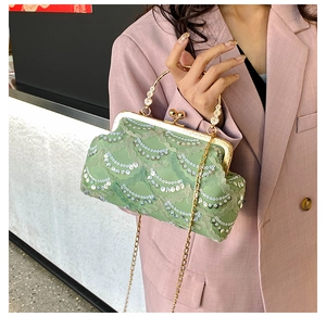 Detail of light green lace handbag featuring silver sequins and floral metal handle