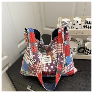 Gros plan du sac cabas patchwork ethnique en velours avec motifs variés et texte brodé