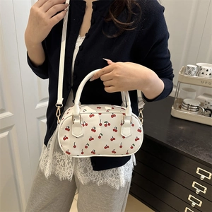Minimalist white shoulder bag with red cherry print featuring double handles and gold hardware