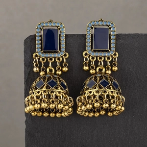 Ethnic vintage Jhumka earrings with blue enamel and gold beads on a stone pedestal