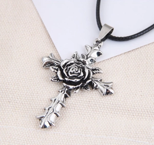 Detailed close-up of a vintage silver gothic cross pendant with an embossed 3D rose design