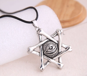 Macro detail of gothic bone star pendant featuring a centered evil eye and oxidized finish