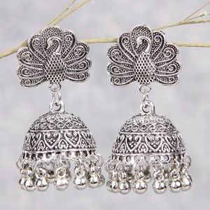 Vintage silver peacock Jhumka earrings with ethnic bell tassels hanging on a branch