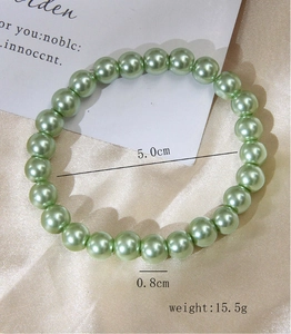 Detail of 0.8cm light green pearl stretch bracelet on satin with 5.0cm inner diameter
