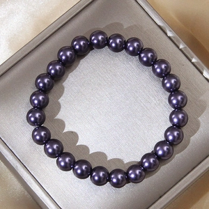 Elegant 8mm round deep purple pearl bracelet displayed on gold silk in jewelry box