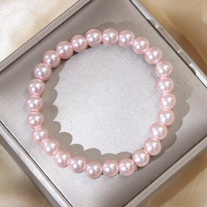 Elegant 8mm pink pearl stretch bracelet presented on silk fabric for a stylish look