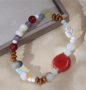 Détail de perles en céramique colorées et breloques en bois sur un bracelet artisanal