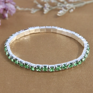 Elegant silver tennis bracelet with emerald green square crystals on vintage fabric