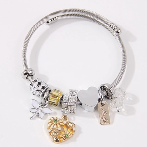 Silver twisted cable bracelet with dragonfly, heart charms, and handmade metal tag