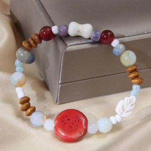 Bracelet bohème en perles de céramique colorées et bois posé sur un coffret à bijoux