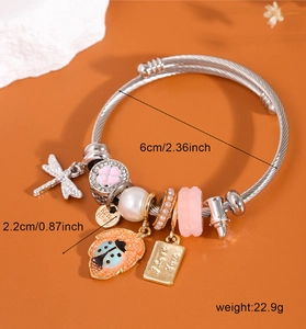 Détail du bracelet argenté avec breloques libellule et mesure du diamètre de 6 cm