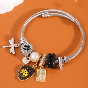 Bracelet jonc argenté avec charms libellule, coccinelle et perles sur fond orange