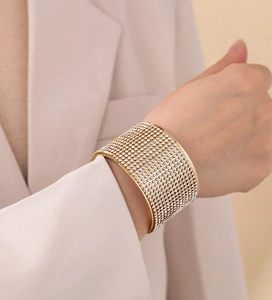 Close-up of golden wide cuff bracelet with 12 rows of sparkling white rhinestones