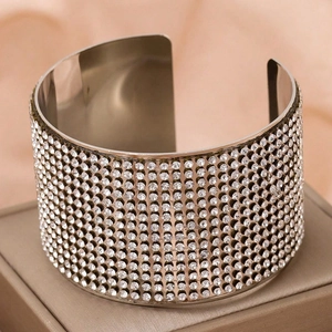 Luxurious wide open silver bangle with sparkling white rhinestones on satin background