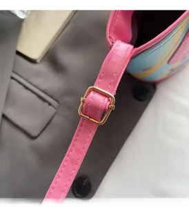 Detail of pink faux leather strap and golden metallic buckle on dachshund bucket bag