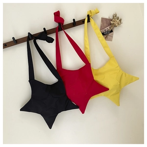 Trois sacs bandoulière en toile en forme d'étoile noirs, rouges et jaunes sur crochets