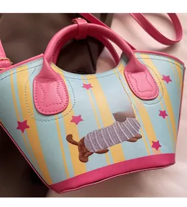 Close-up of dog embroidery on striped bucket bag with comfortable soft leather texture