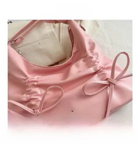 Detail der rosa gefalteten PU-Ledertasche mit Schleifen und silbernen Metallschnallen