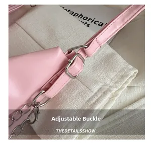 Detail des verstellbaren Riemens mit Silberschnalle und Kette am rosa Faltenrucksack