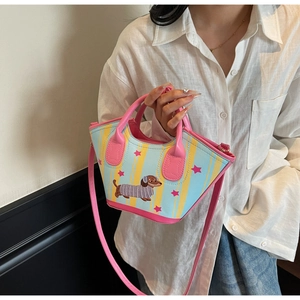 Detail of dachshund print bucket bag with pink handles worn by a model in casual outfit