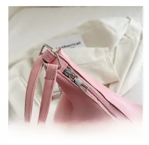 Nahaufnahme von silbernem Metallreißverschluss und Schnalle am rosa Faltenrucksack