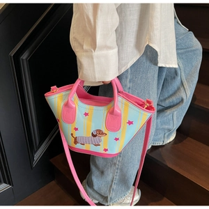 Detailed shot of striped tote bag featuring dachshund print on a wooden staircase
