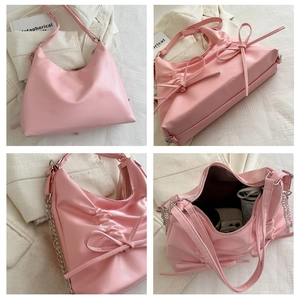 Detailansicht des rosa Schleifenrucksacks mit Innenfach, Metallkette und glänzendem PU-Material