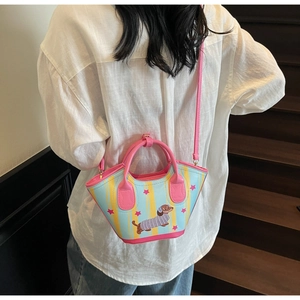 Detail of dachshund bucket bag with pink handles and strap shown on a model