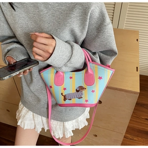 Detailed view of the striped dachshund pattern handbag worn by a model in casual style