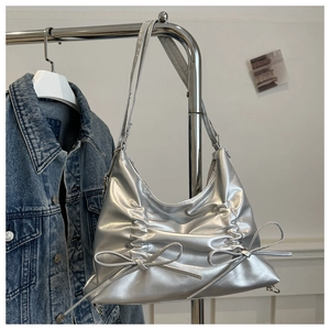 Detailaufnahme der silbernen Hobo-Tasche mit Falten-Optik und Dekoschleifen